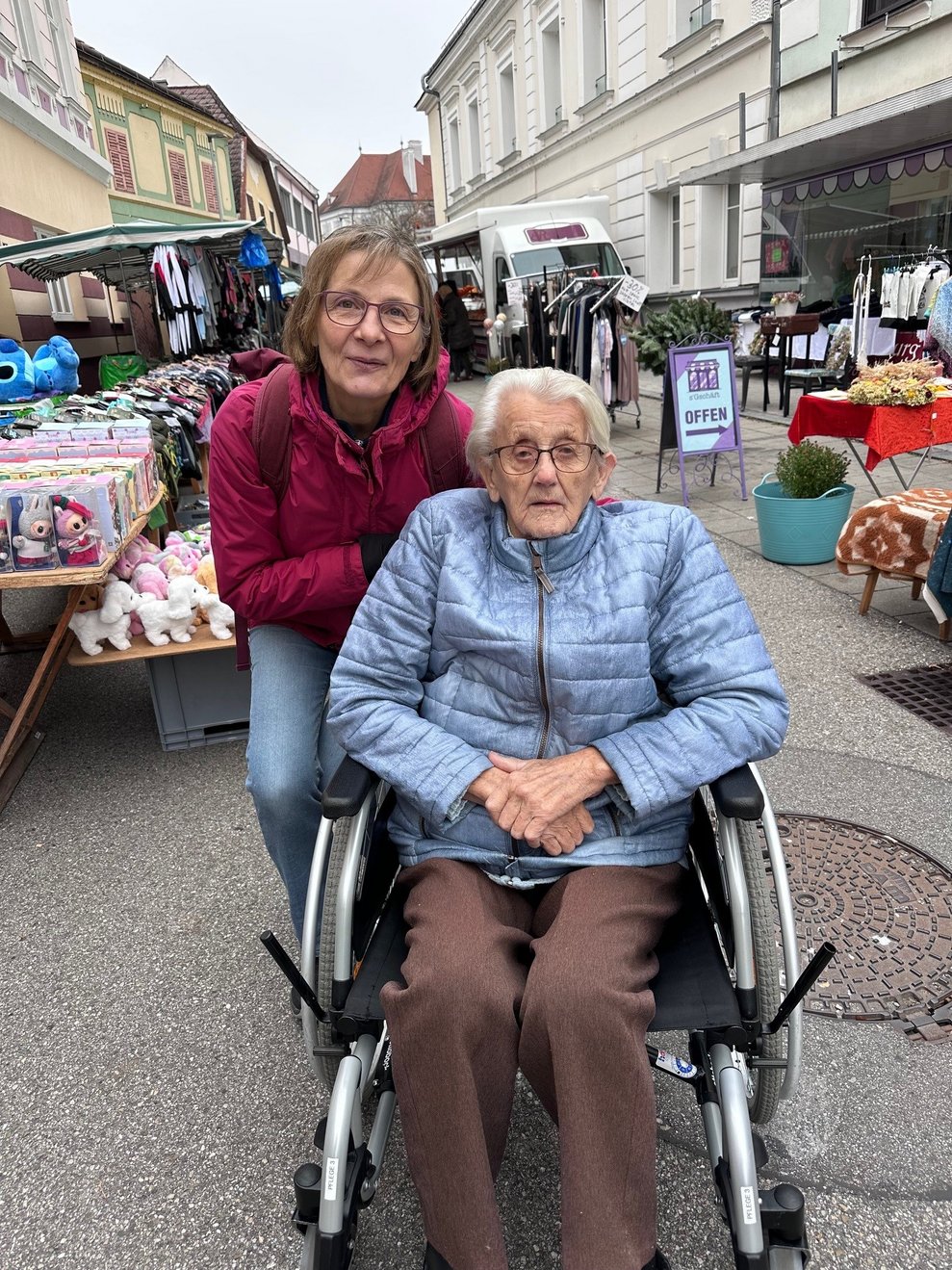 Eine Dame im Rollstuhl und eine Begleitperson beim Markt