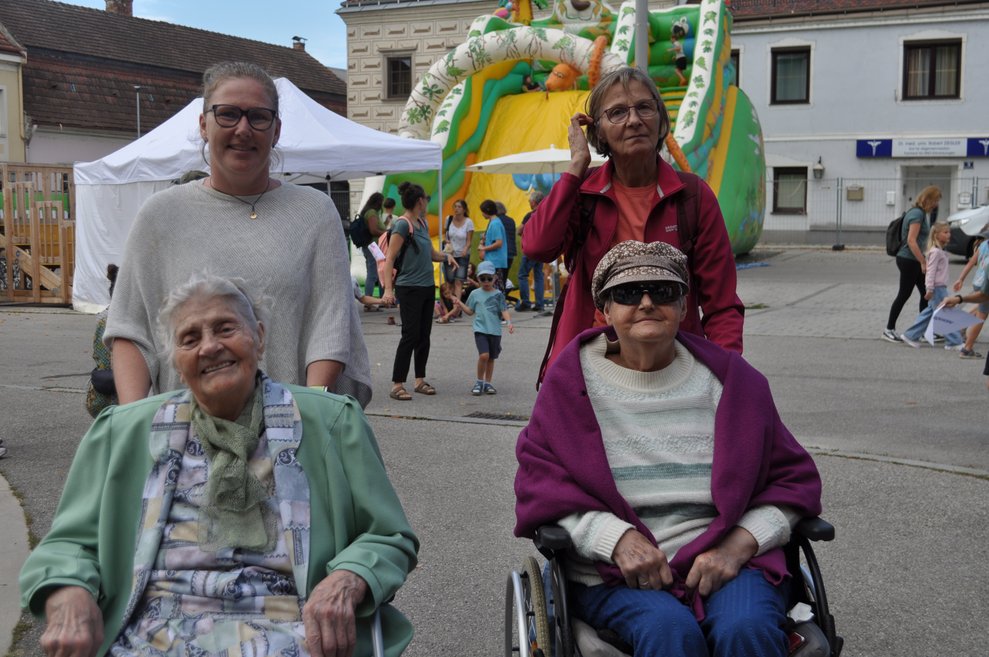 Zwei ältere Damen im Rollstuhl mit zwei Begleitpersonen bei den NÖKISS Herzogenburg