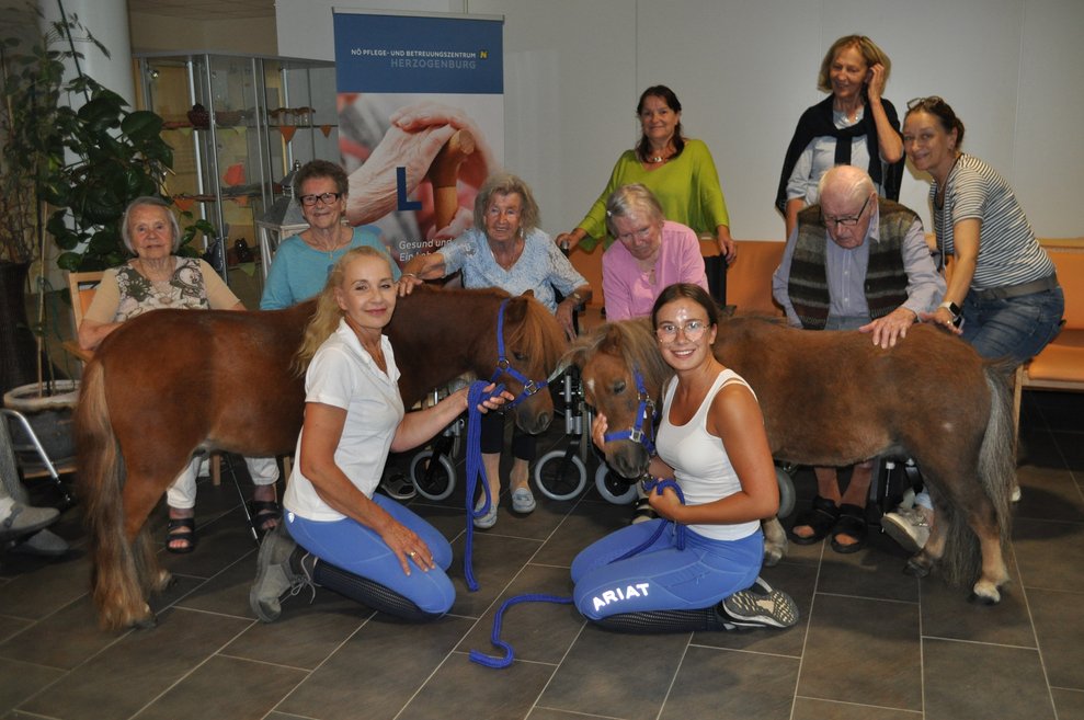 Zwei Trainerinnnen, zwei Ponys und mehrere ältere Personen