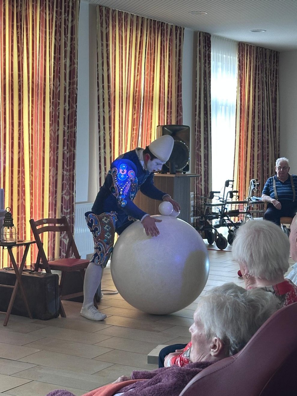 ein Clown bei seiner Vorstellung mit einem großen weißen Ball