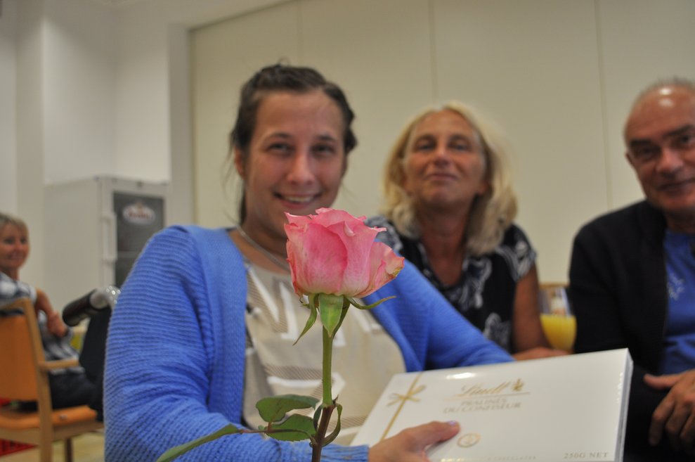 eine junge Frau mit BLume und Pralinen bei der Geburtstagsfeier