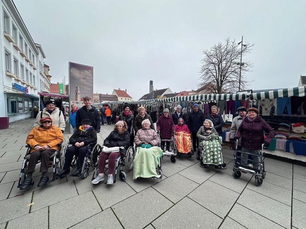 ein Gruppenfoto von einigen Personen im Rollstuhl und Rollator und Begleitpersonen beim Markt in Herzogenburg