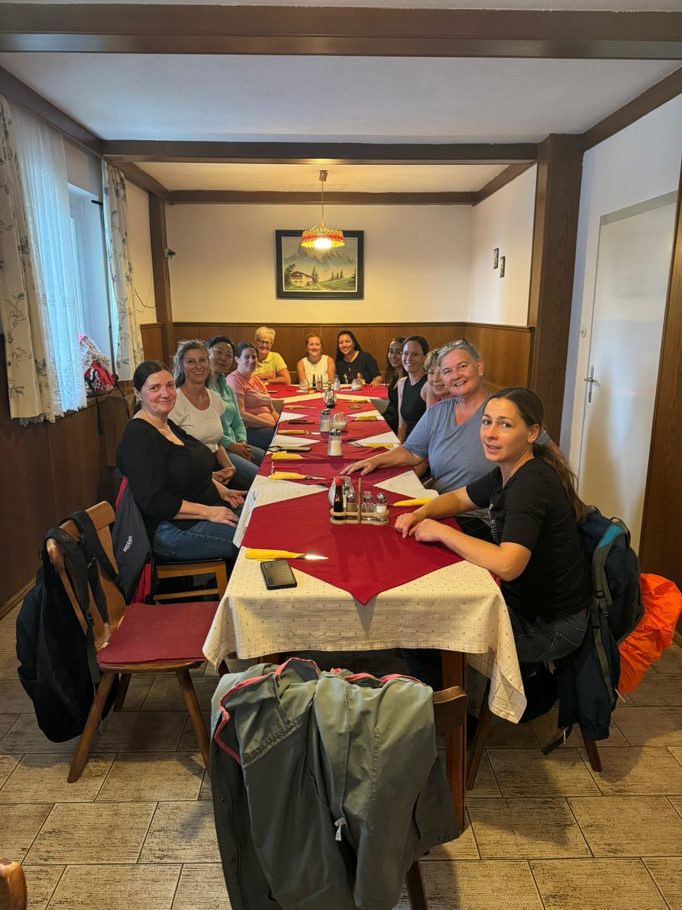 Gruppenfoto im Gasthof mit gedecktem Tisch.