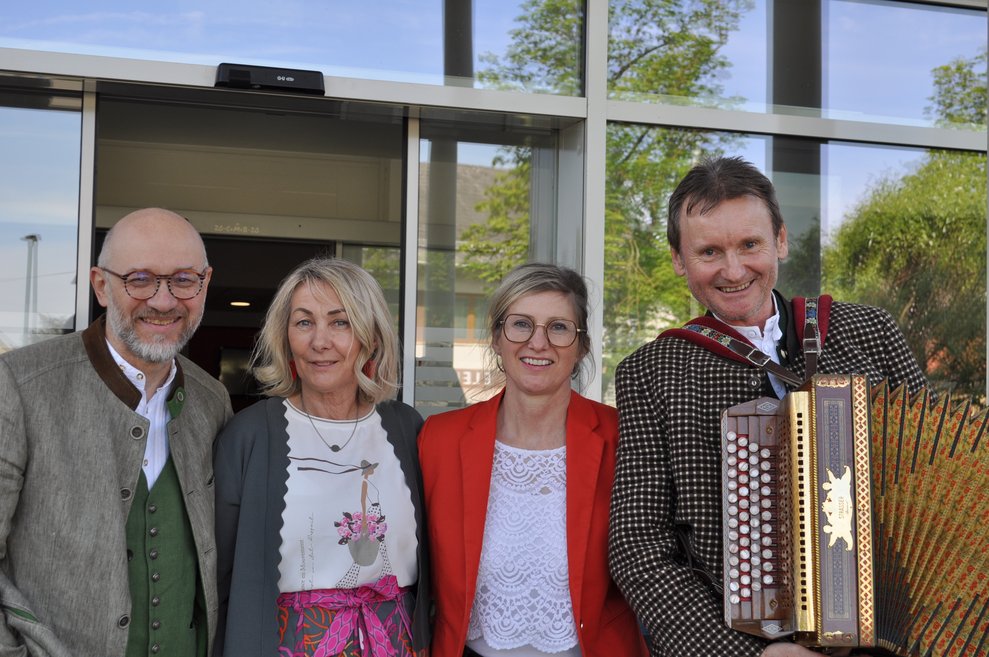 Zwei Frauen und ein Mann mit dem Ziehharmonika Spieler