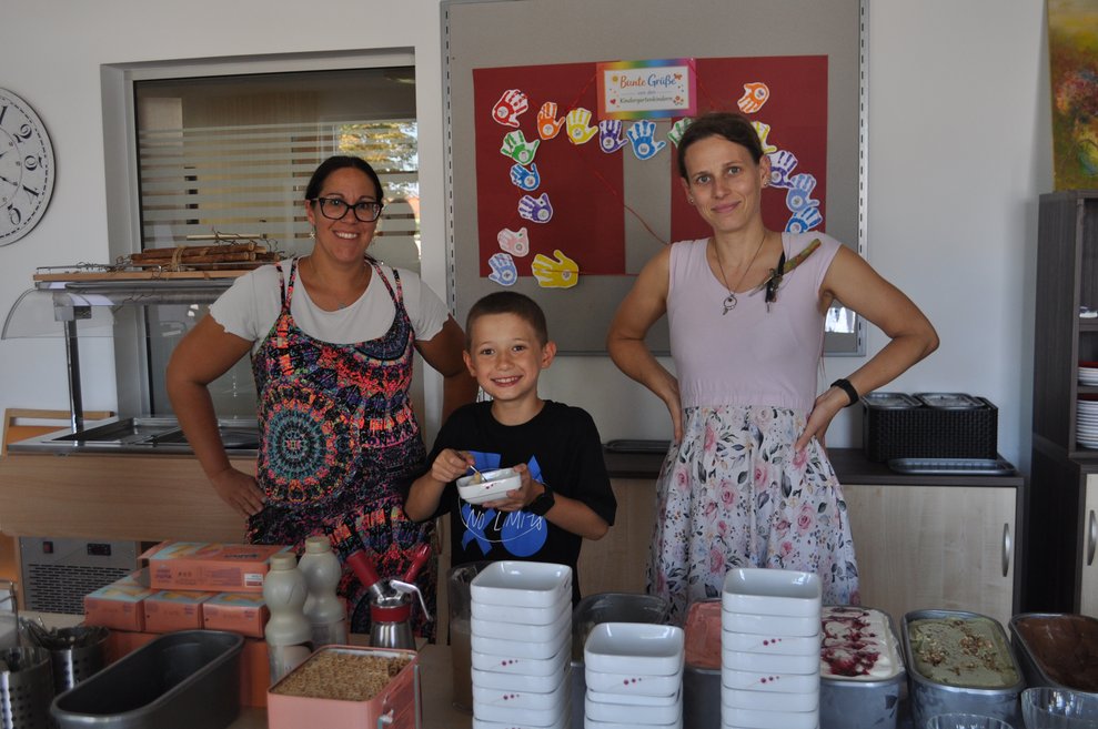 zwei Frauen und ein Kind beim Eis portionieren
