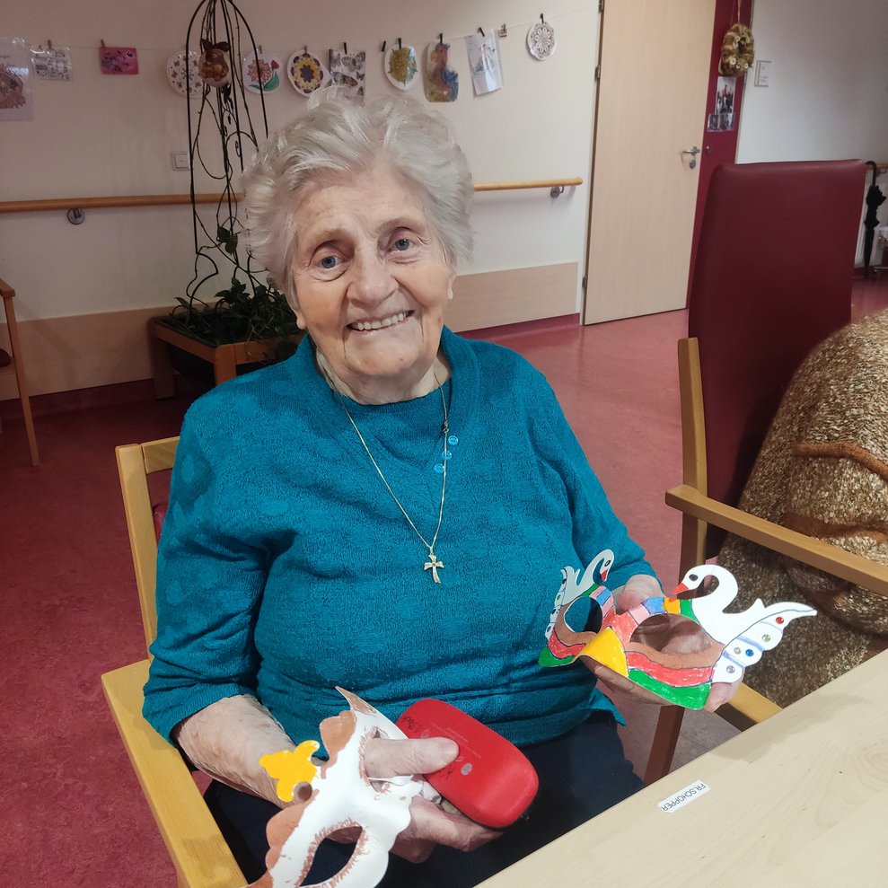 eine ältere Dame mit einer selbstgebastelten Faschingsmaske