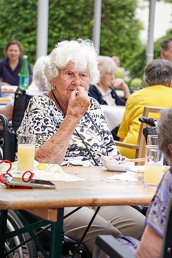 Eine ältere Dame isst ein Eis mit Röllchen