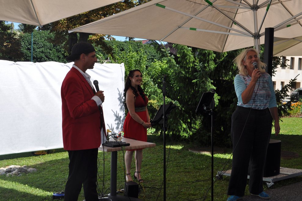 die Pflegedirektorin bei der Ansprache und ein Sänger und eine Sängerin