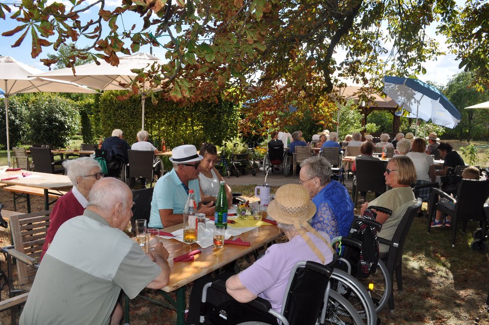 mehrere Menschen im Garten beim Gartenfest