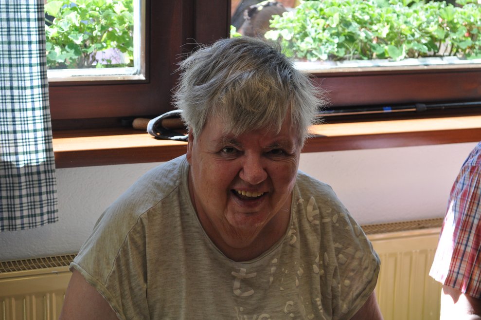 eine ältere Frau beim Heurigen