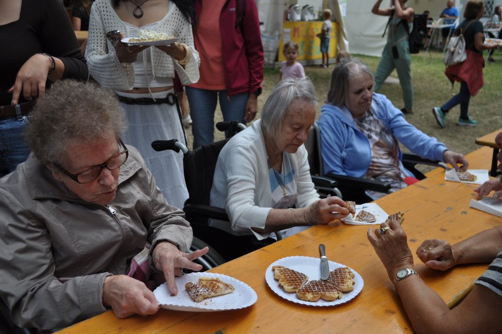 mehrere Personen essen Waffeln mit Zucker