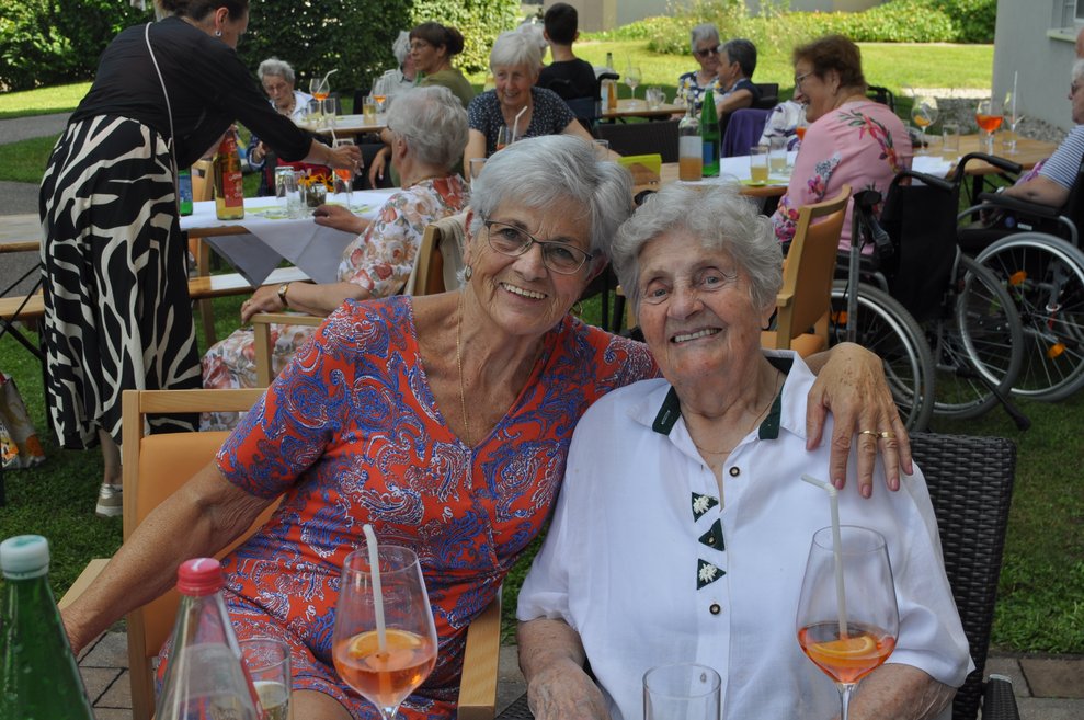 zwei Damen mit den Armen umschlungen bei der Terasse
