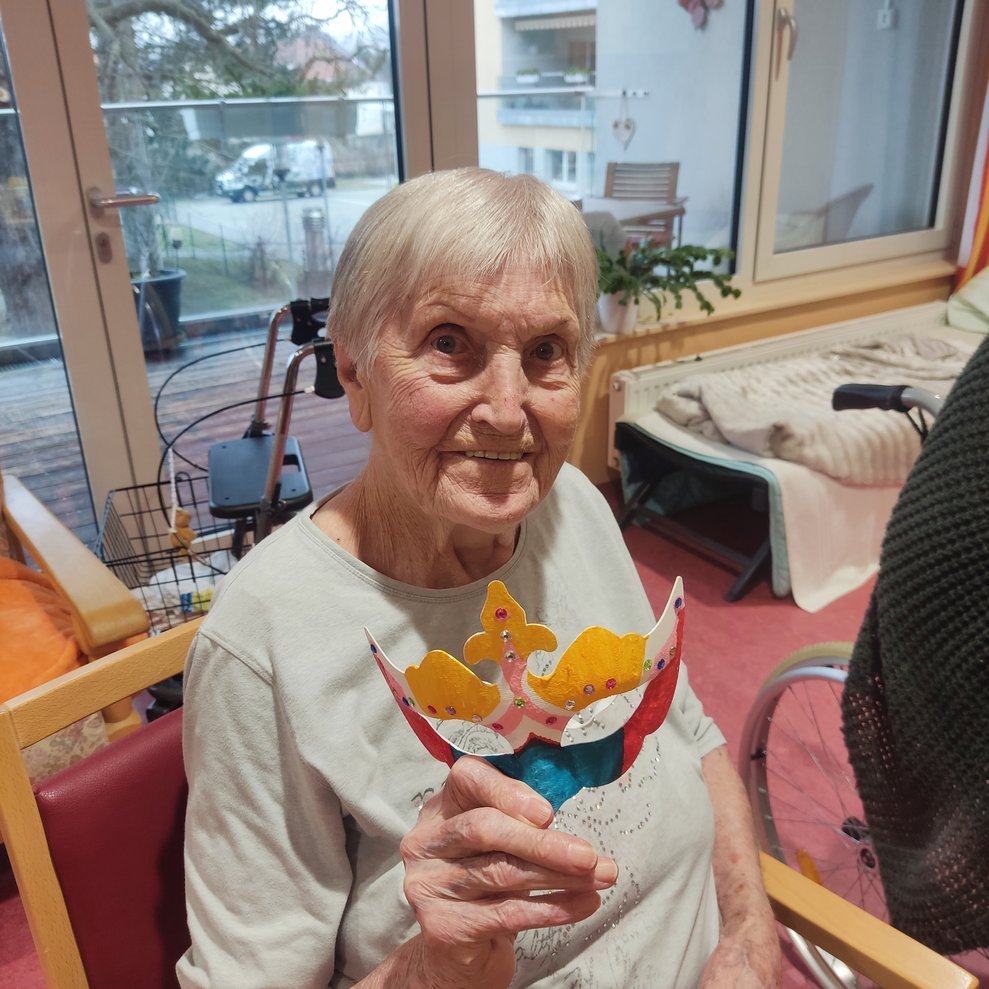 eine ältere Dame mit einer selbstgebastelten Faschingsmaske