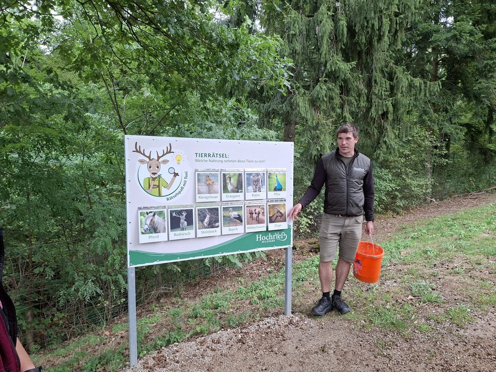 Führung vom Inhaber durch den Wildpark, ein Mann steht vor einer großen Info Tafel