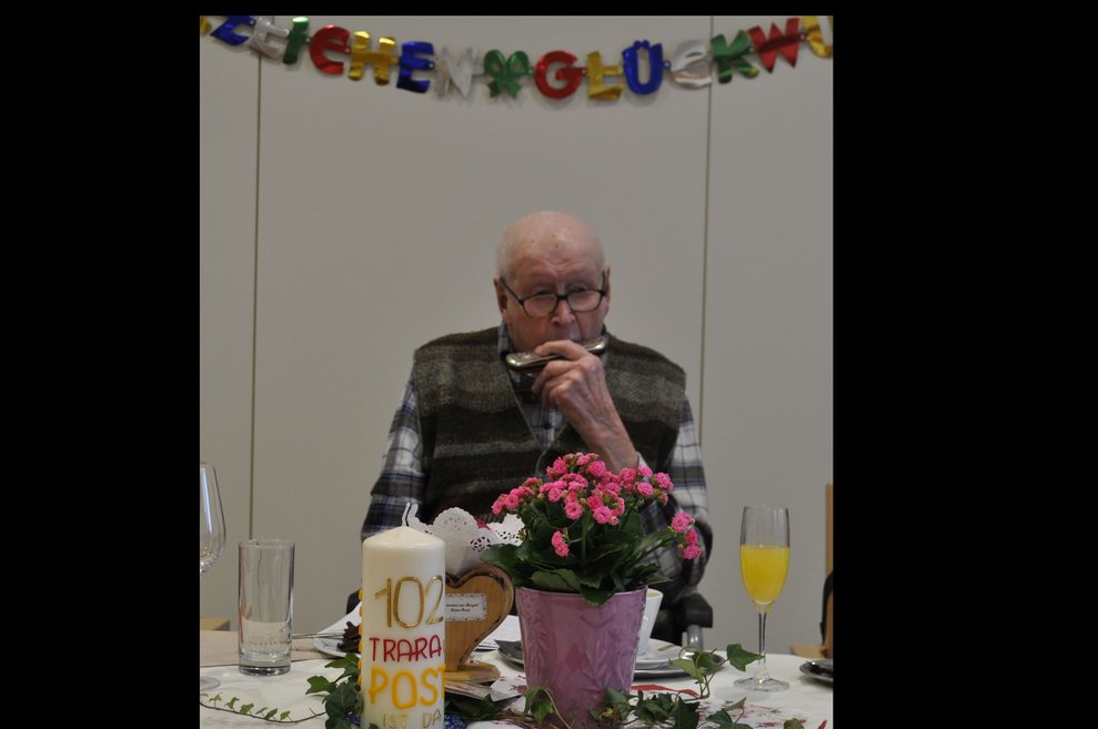 ein alter Mann spielt Mundharmonika