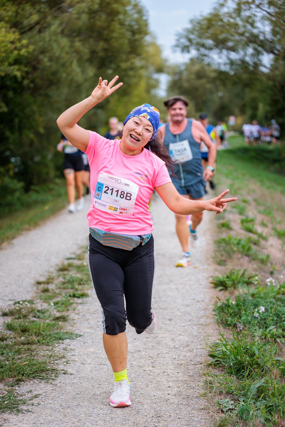 eine Frau mit rosa Trikot auf der Laufstrecke