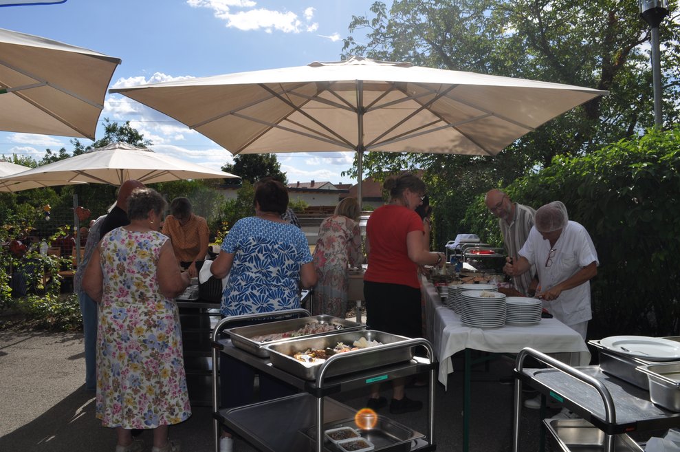 einige Personen richten das Essen her vom Buffet der Heurigenjause