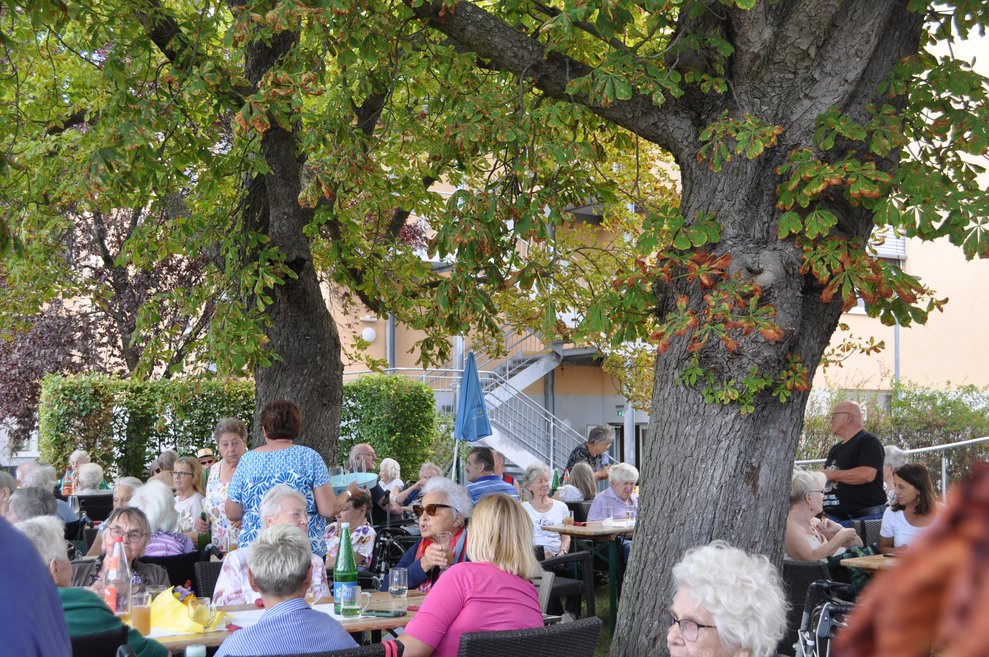 Menschen sitzen im Garten beim Fest