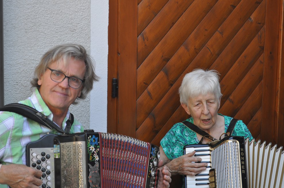 Zwei Musikanten mit Zieharmonika, ein Mann und eine ältere Frau