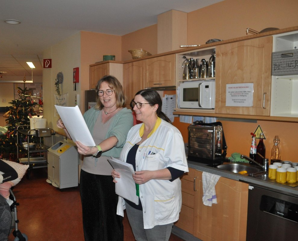 Zwei Damen lesen etwas vor bei der Weihnachtsfeier