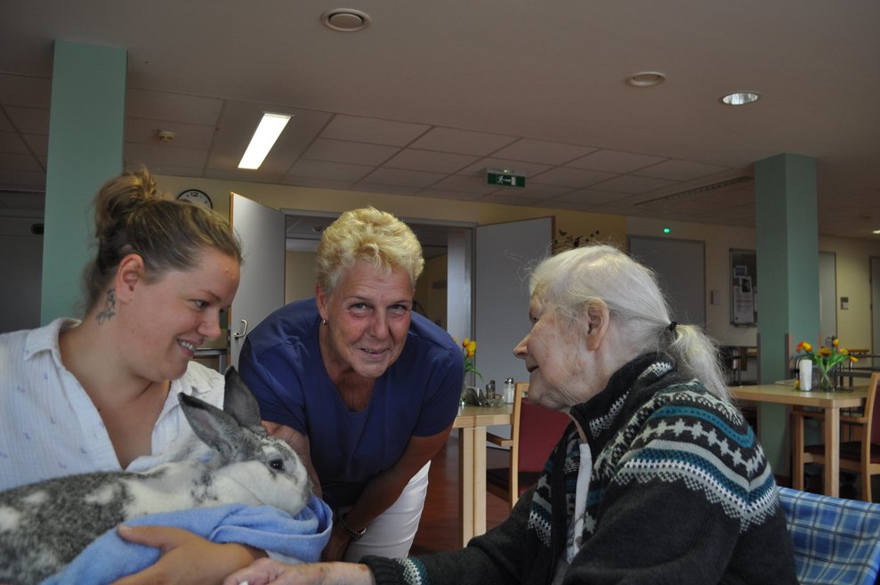 eine ältere Dame und zwei andere Damen mit einem Hasen am Arm