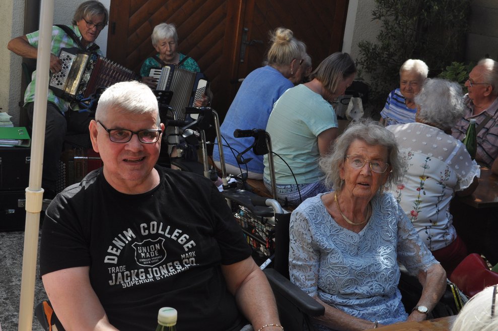 Ein Mann und eine Frau im Rollstuhl beim Heurigen