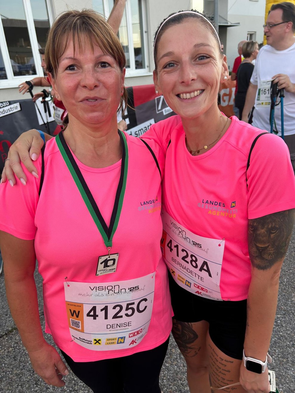 zwei Damen mit pinken Sport T-Shirts und einer Medaille