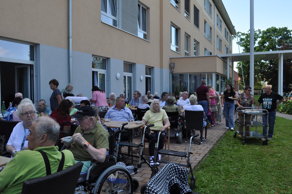 mehrere Leute im Garten vor dem Pflegeheim beim italienischen Nachmittag