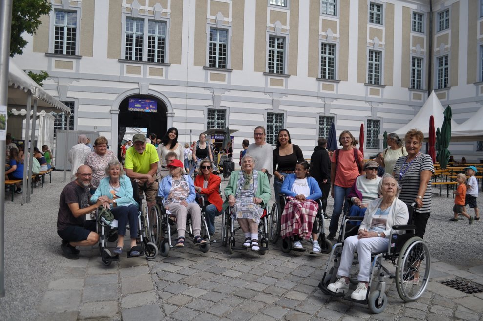 Mehrere Personen in Rollstühlen und Rollatoren vor Stift Herzogenburg