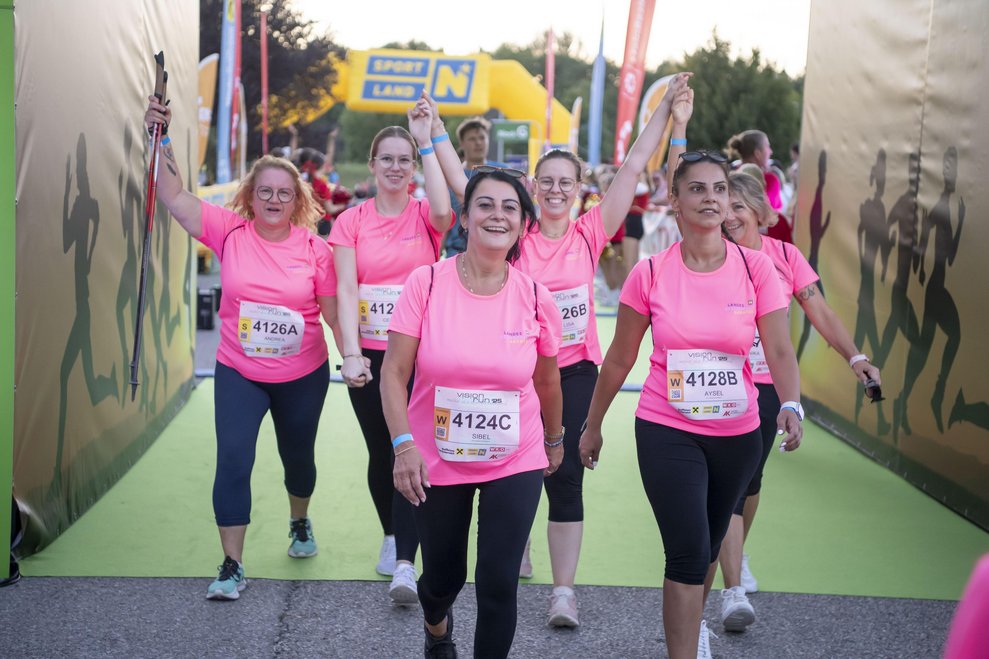 mehrere Personen im Zieleinlauf mit pinken T-Shirts