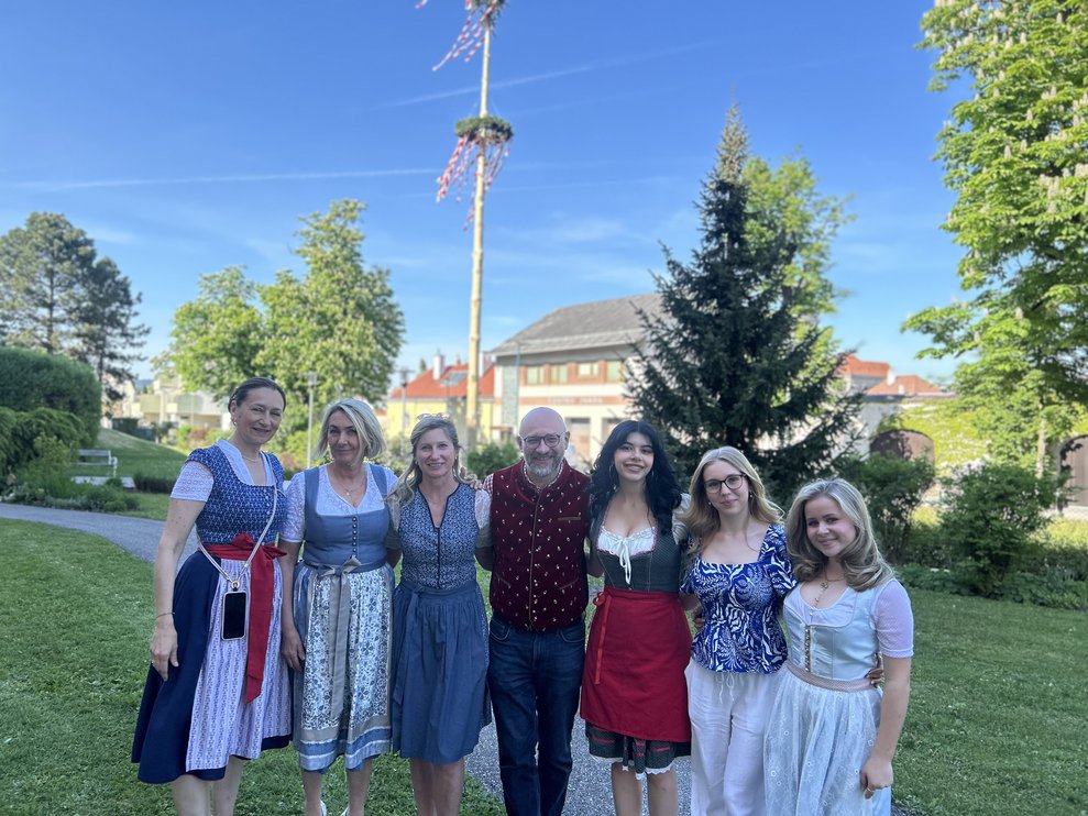 Mehrere Personen stellen sich vor den Maibaum für ein Gruppenfoto
