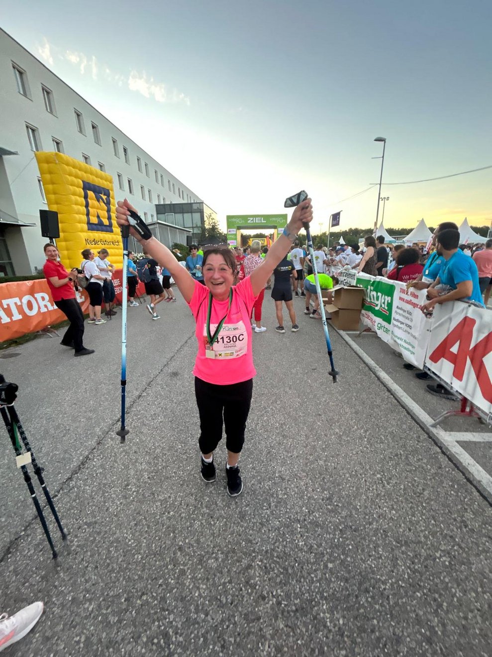 eine Frau ganz froh im Ziel, die Hände in die Höhe