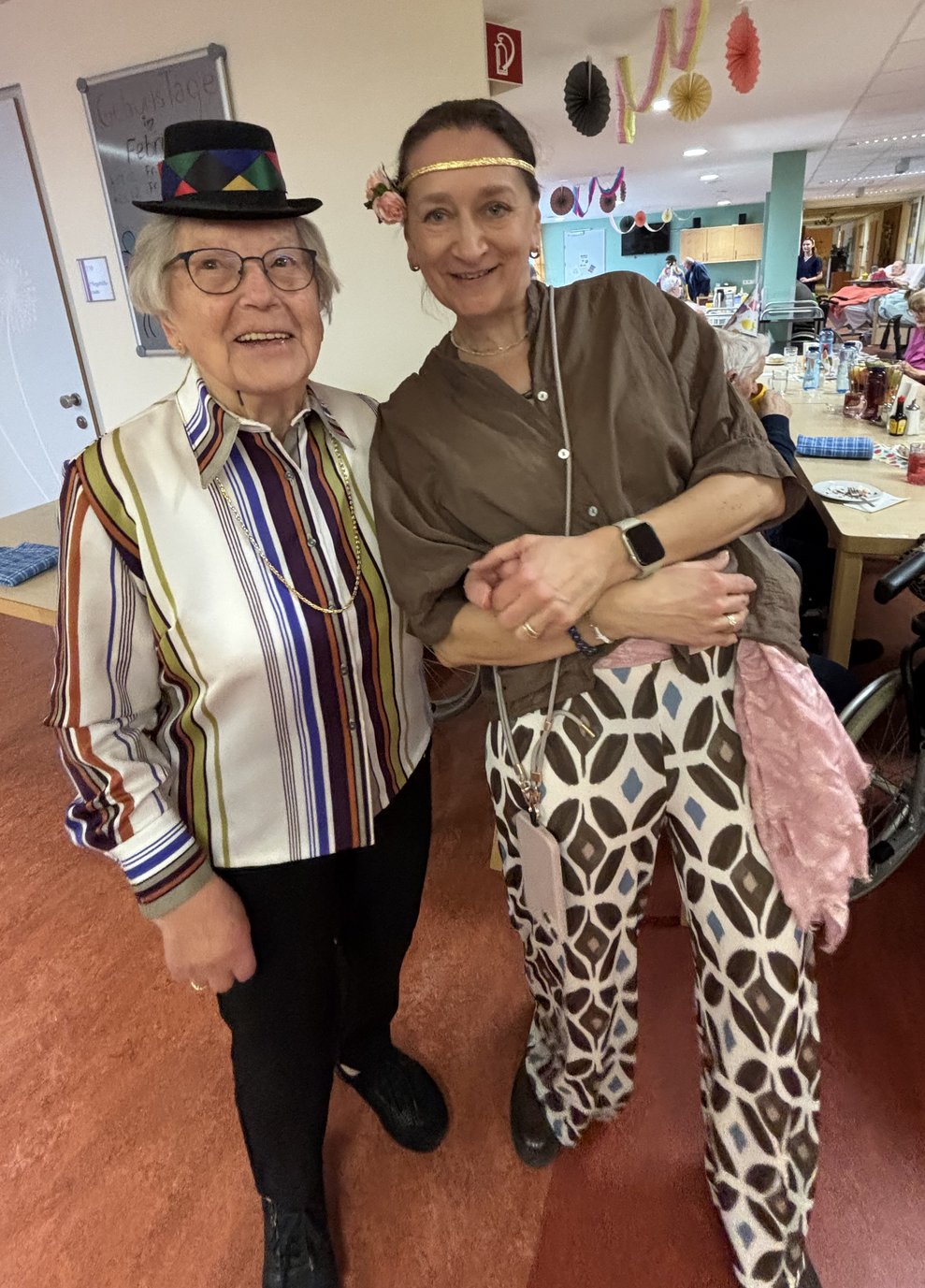 eine ältere Dame mit Hut und eine Frau als Hippie verkleidet