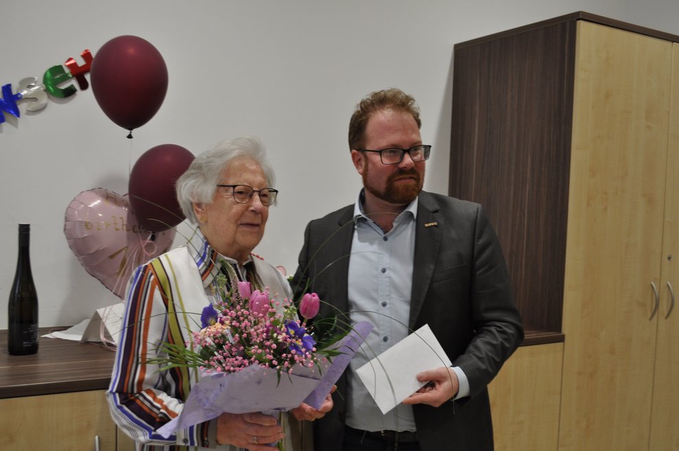 eine ältere Damen mit Blumen in der Hand und der Bürgermeister