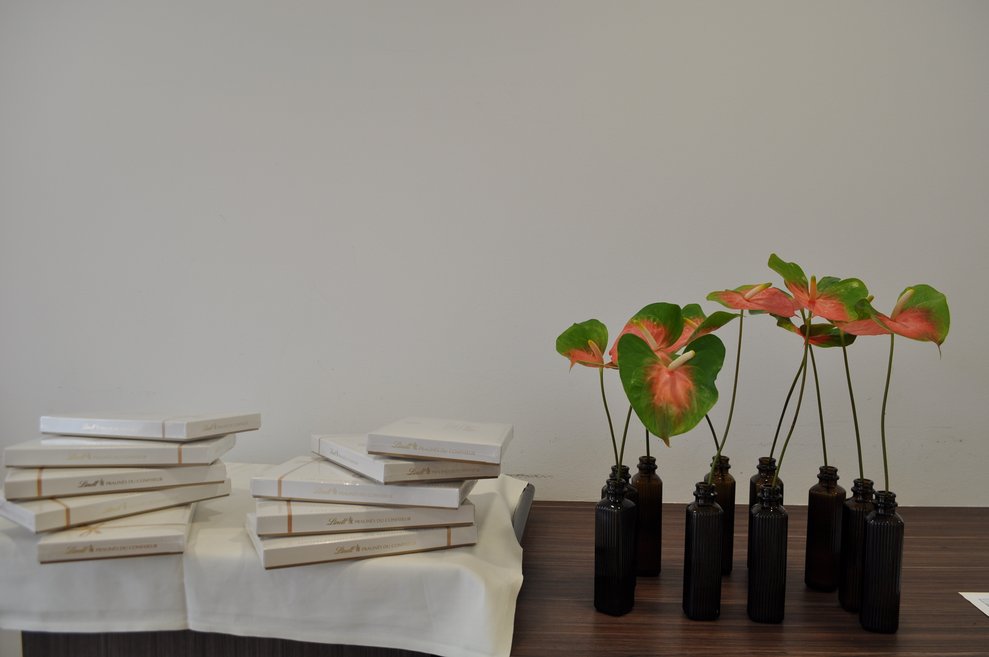 weiße Lindt Pralinen und Blumen in kleinen Vasen