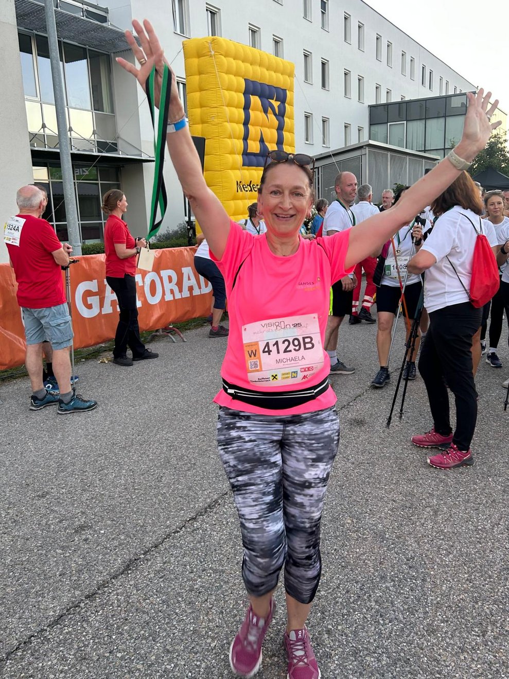 eine Frau ganz froh im Ziel, die Hände in die Höhe