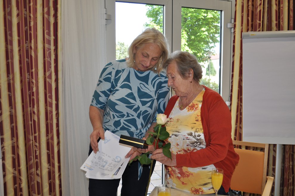 bei der Geburtstagsfeier, zwei Frauen mit Blumen und Pralinen