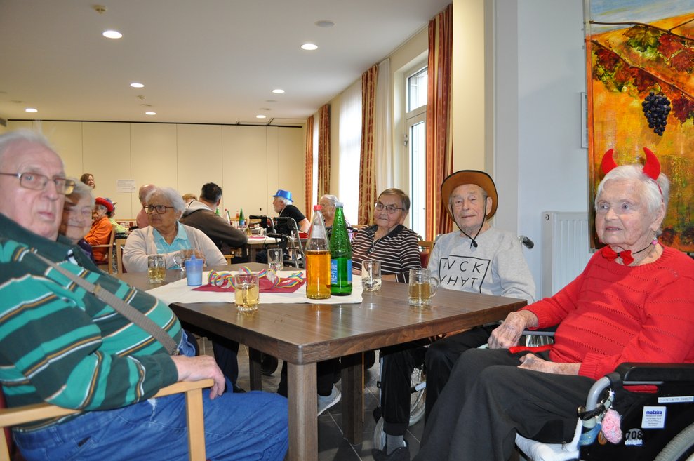 einige Personen in Rollstühlen und auf Sesseln bei der Faschingsfeier