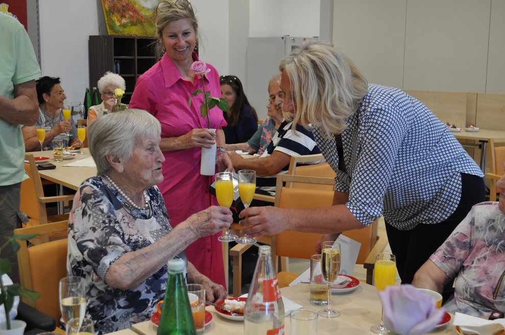 eine Frau gratuliert einer älteren Dame zum Geburtstag