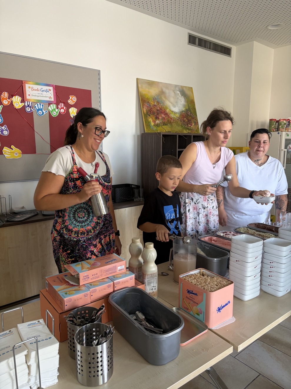drei Frauen und ein Junge beim Eis portionieren 