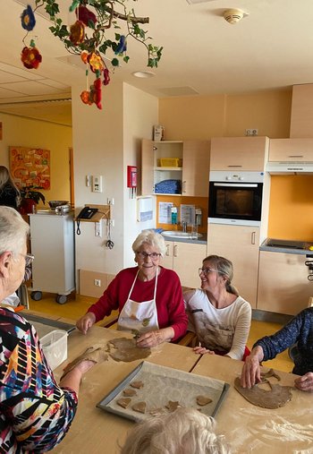 eine ältere Dame und eine jüngere beim Kekse ausstechen