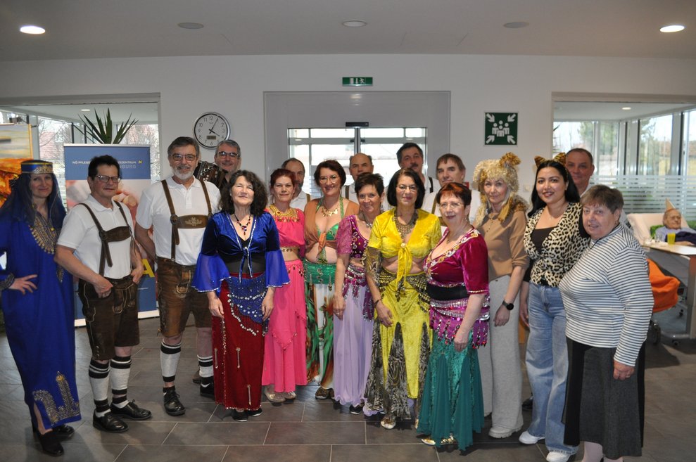 ein Gruppenfoto mit Bauchtänzerinnen und Schuhplattlern und verkleideten Personen
