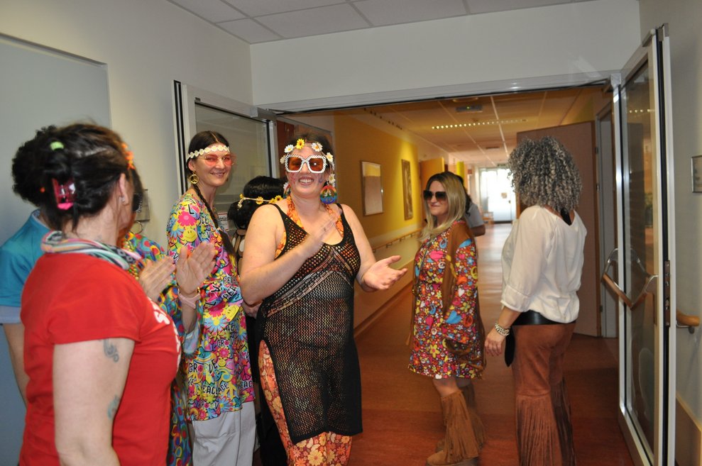 einige Personen als Hippies verkleidet tanzen und klatschen