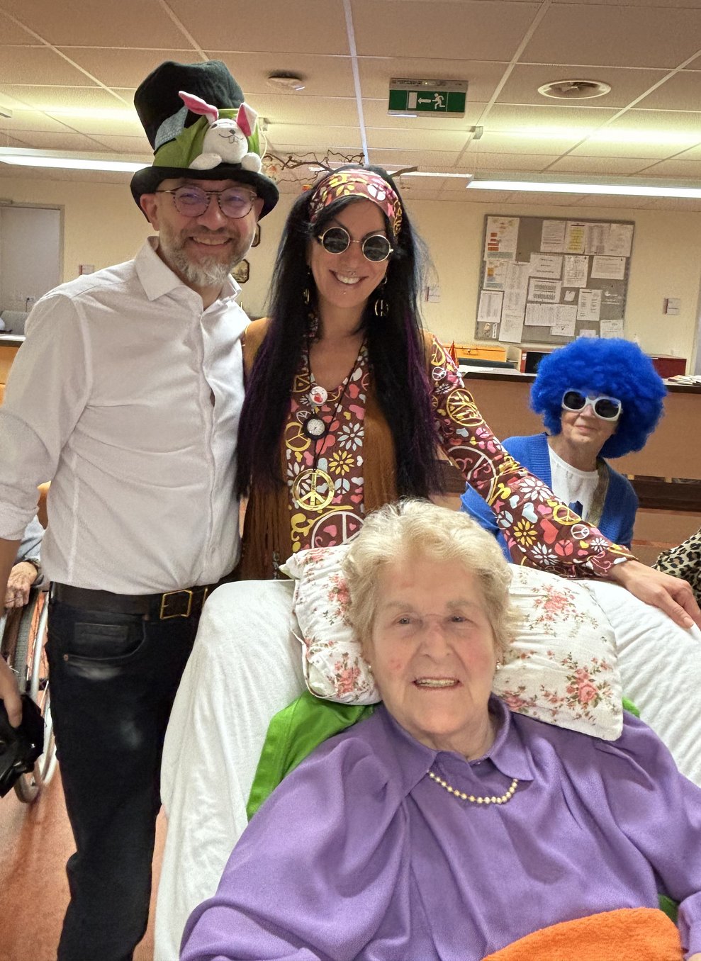 ein Mann mit großen Faschingshut, eine Frau als Hippie verkleidet, eine Frau mit blauere Perücke und eine ältere Dame im Cosy Chair