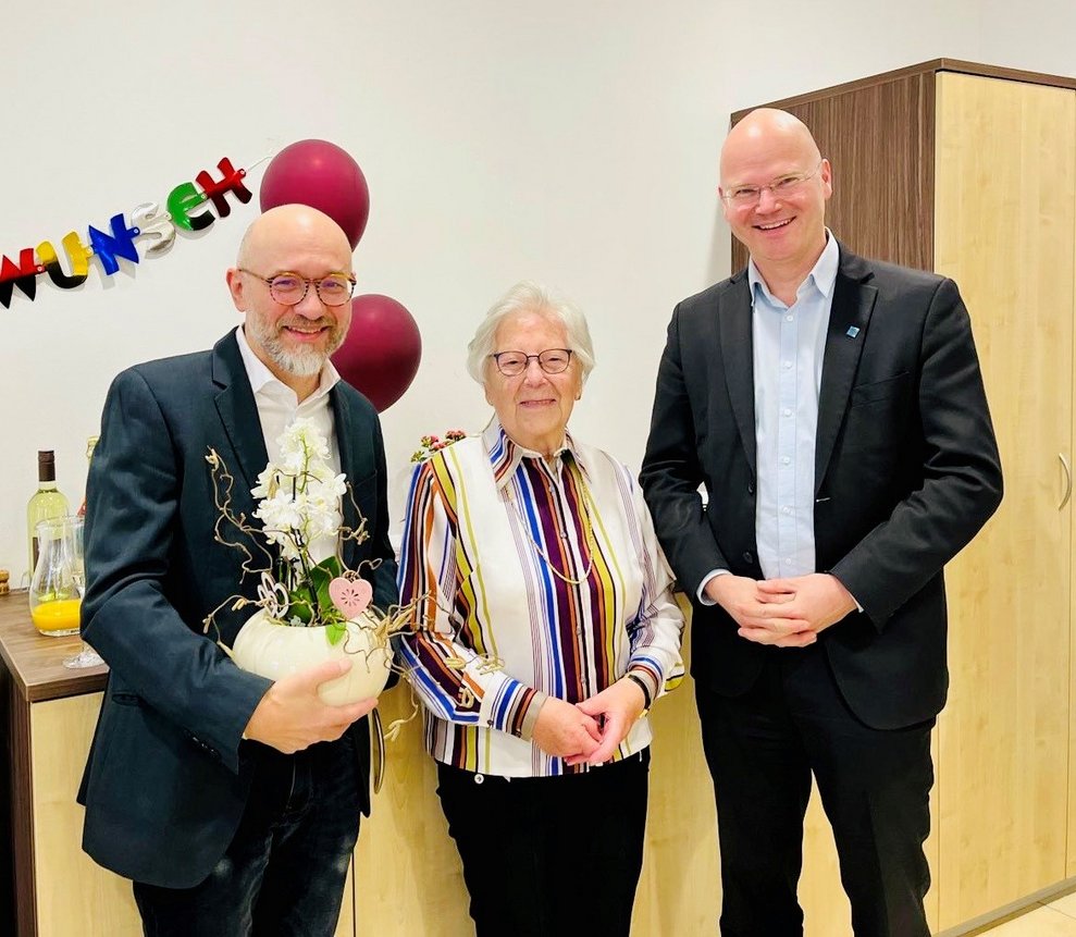 Zwei Männer mit einer älteren Dame beim Gratulieren zum 101. Geburtstag