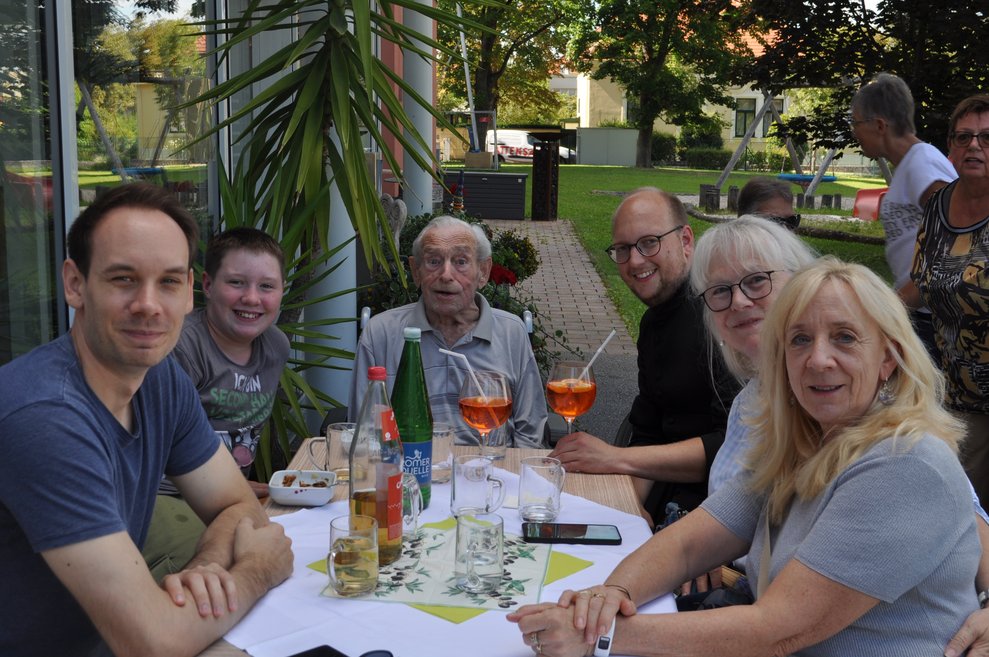 mehrere Personen im Garten mit Getränken