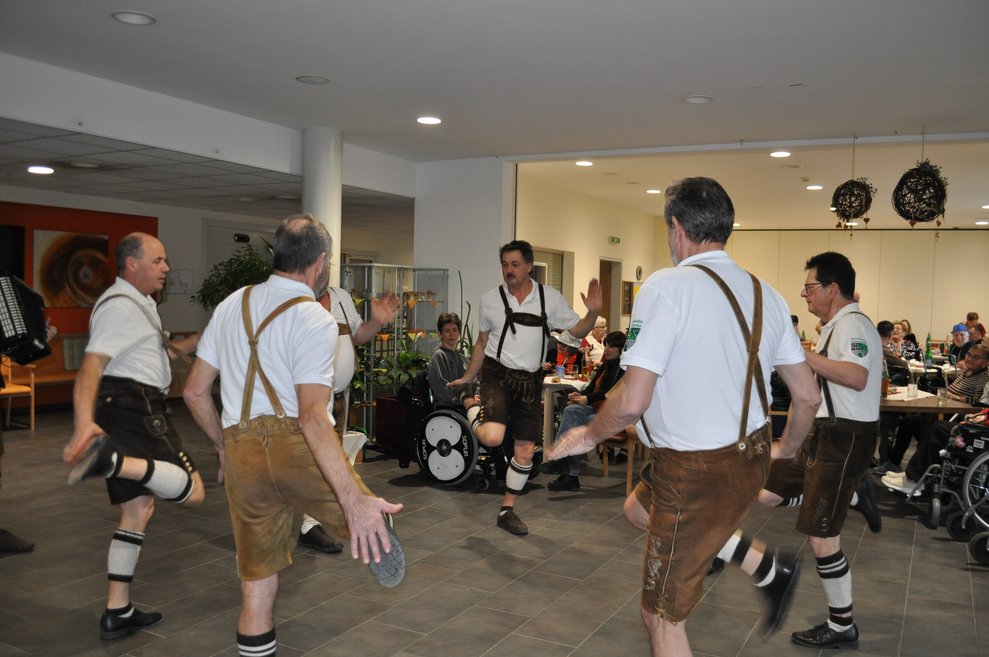 mehrere Männer in Lederhosen beim Schuhplattler Tanz