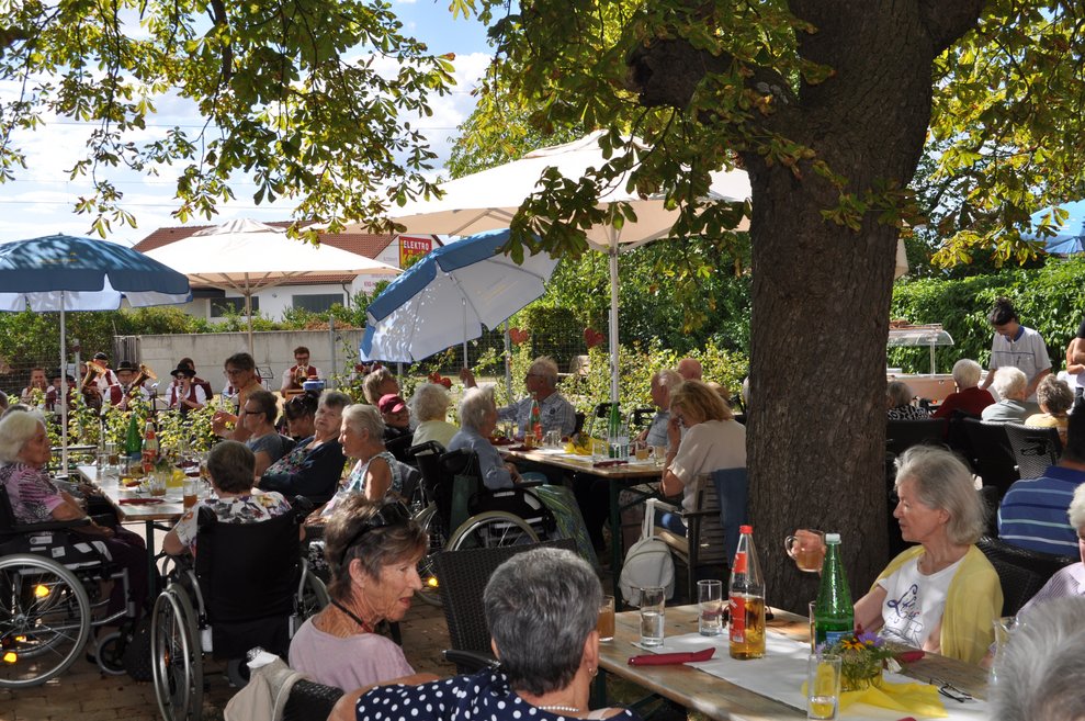 Menschen sitzen im Garten beim Fest