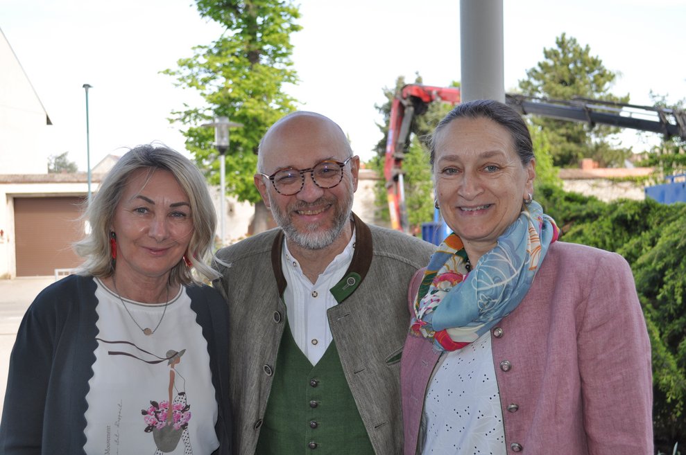 Zwei Frauen und ein Mann beim Maibaum aufstellen