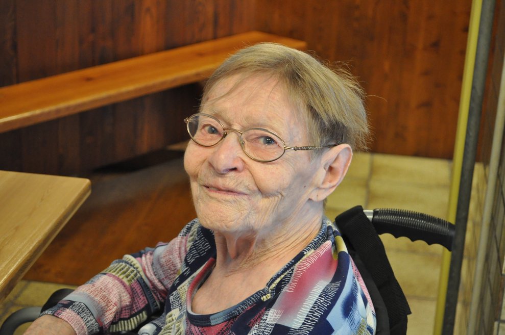 eine ältere Frau beim Heurigen